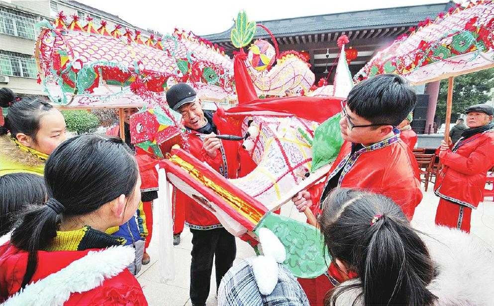 1月17日,宜秀区非遗传承人72岁的胡忠富正在为胡氏龙灯点睛,吸引不